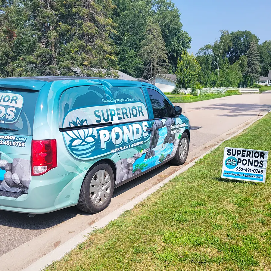 Superior Ponds branded van parked beside sign showcasing professional pond and waterfall installation services.